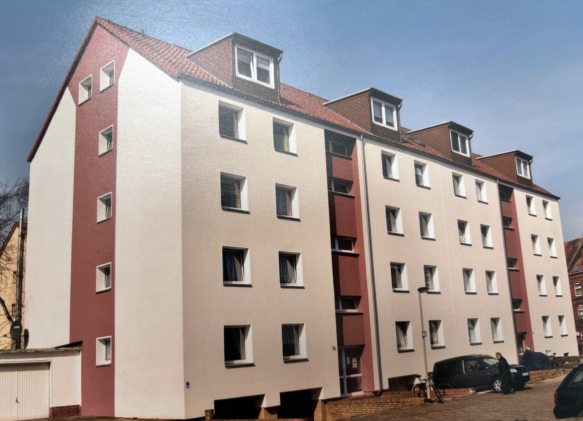 Viergeschossige Wohnhäuser Am Büchenberge, weiß verputzt mit rotbraunen Treppenhausachsen und Dachgauben